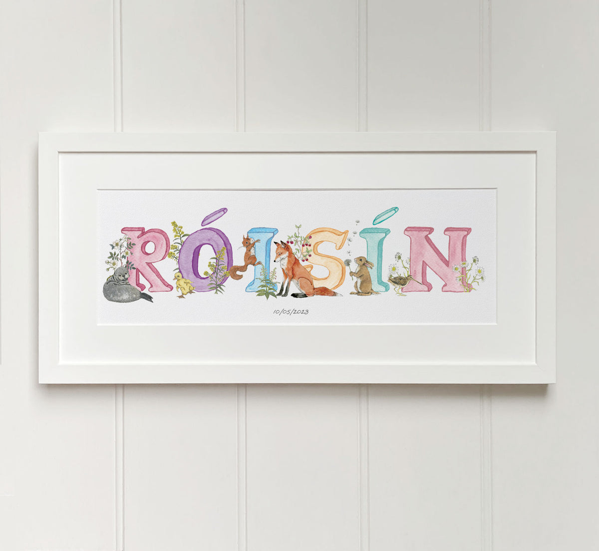 Personalised alphabet name in pastel colours in Irish language watercolour letters fine art print in white wooden frame. Baby gift.