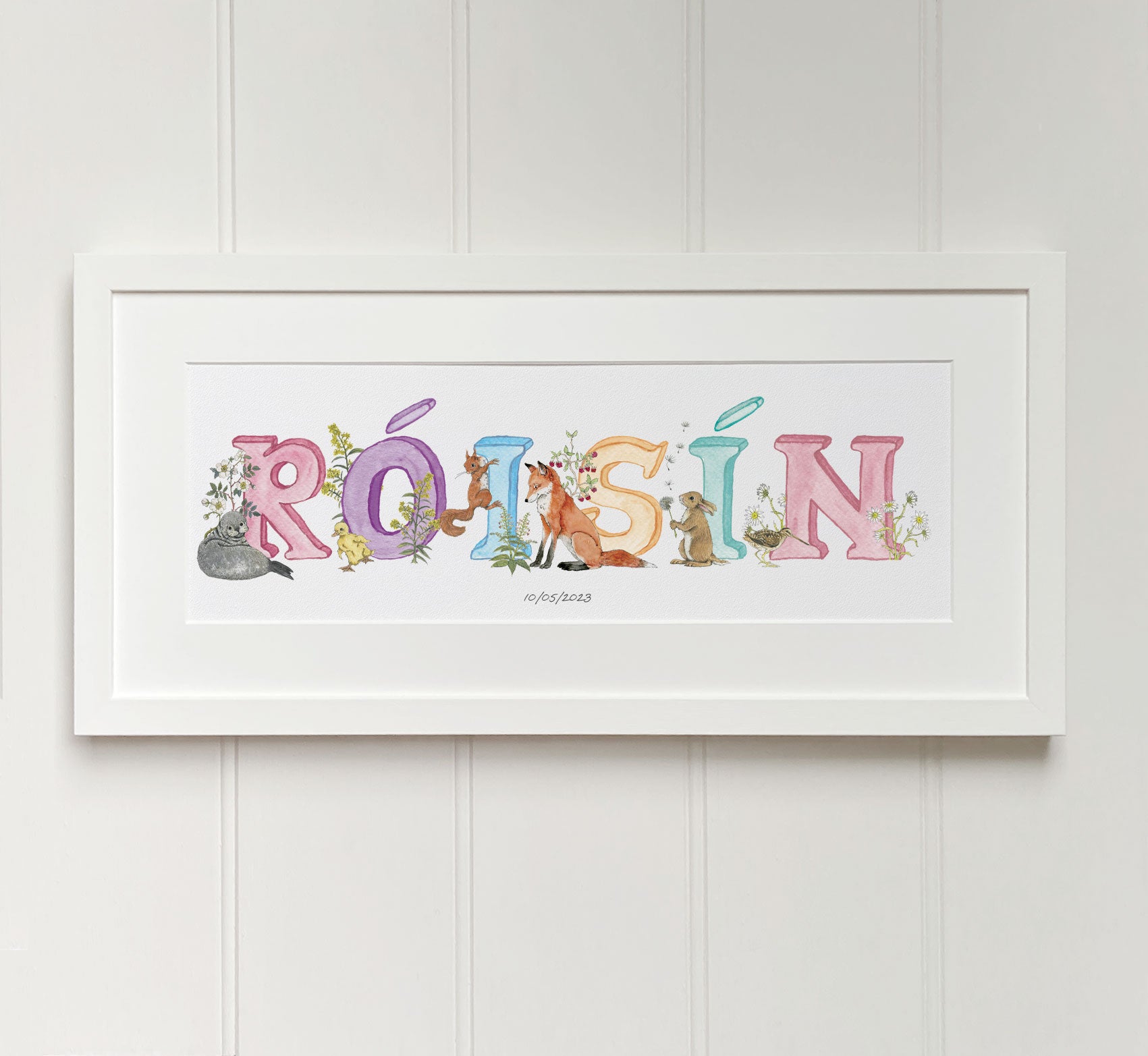 Personalised alphabet name in pastel colours in Irish language watercolour letters fine art print in white wooden frame. Baby gift.